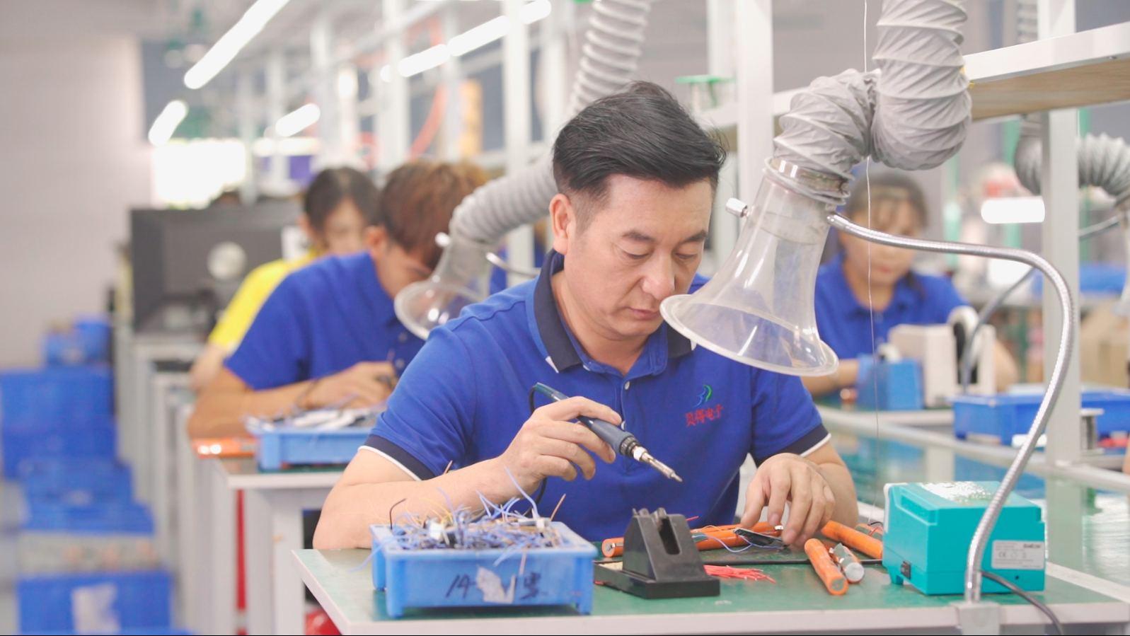 Technician hand-soldering battery pack